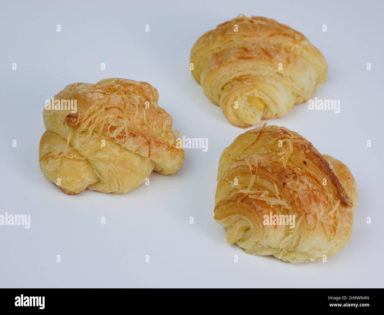 primo piano di tre croissant al formaggio su sfondo bianco Foto Stock