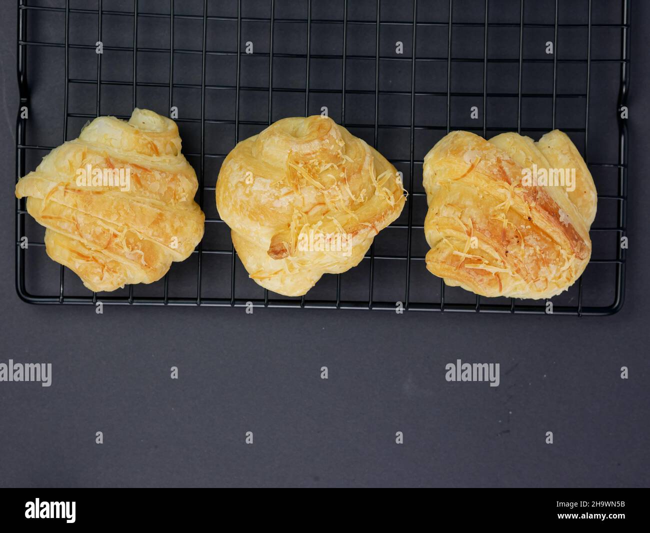 vista dall'alto del croissant al formaggio sul grill su sfondo nero Foto Stock