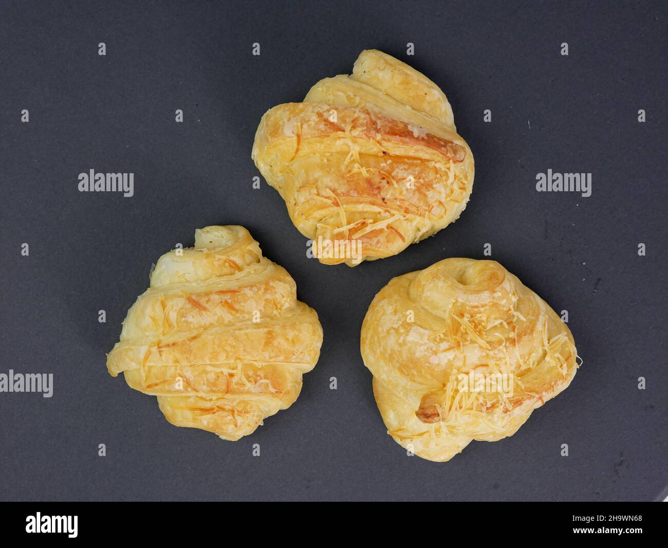 vista dall'alto di tre croissant al formaggio su sfondo nero Foto Stock