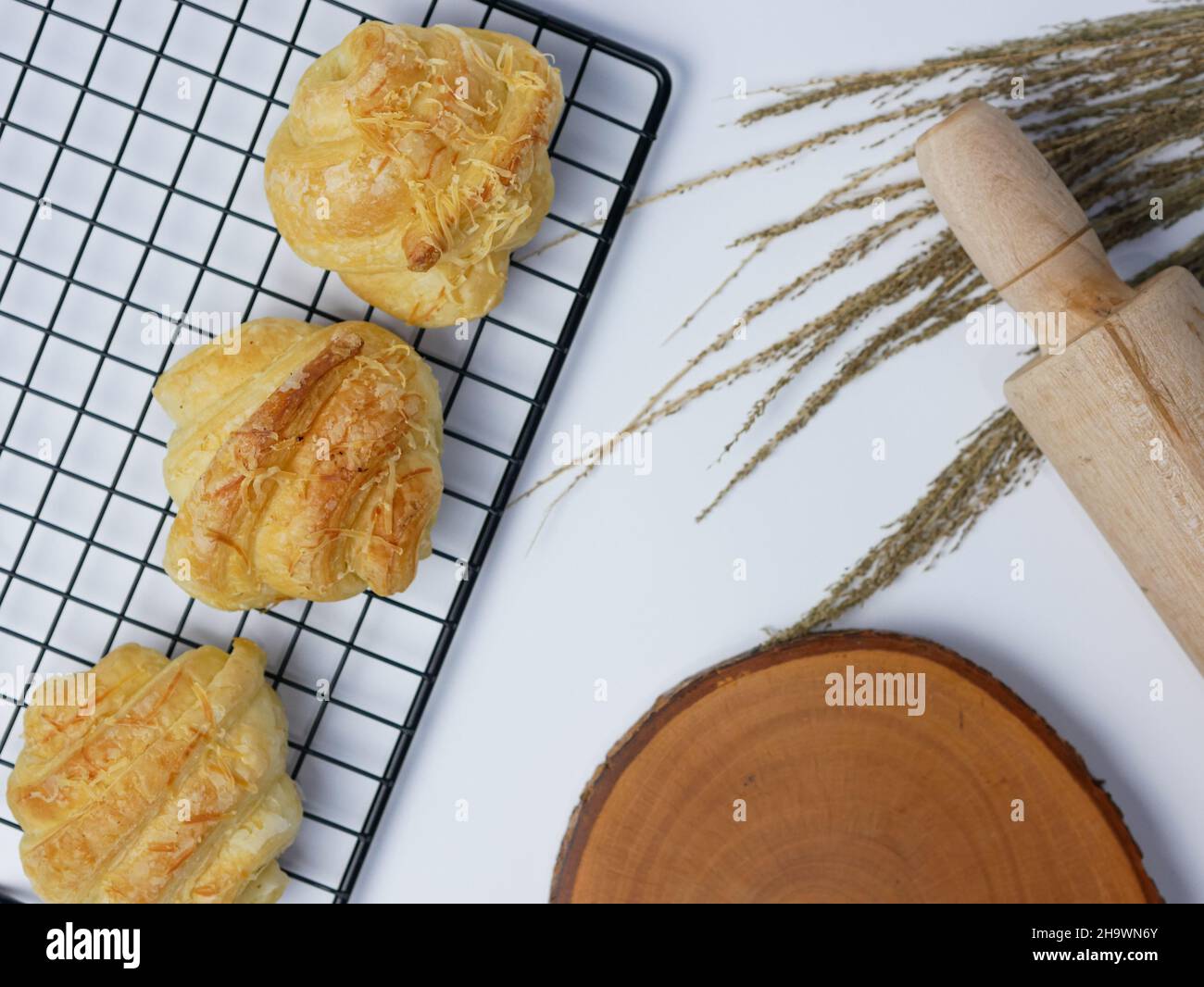 croissant sul grill, tagliere in legno e spilla su sfondo bianco Foto Stock