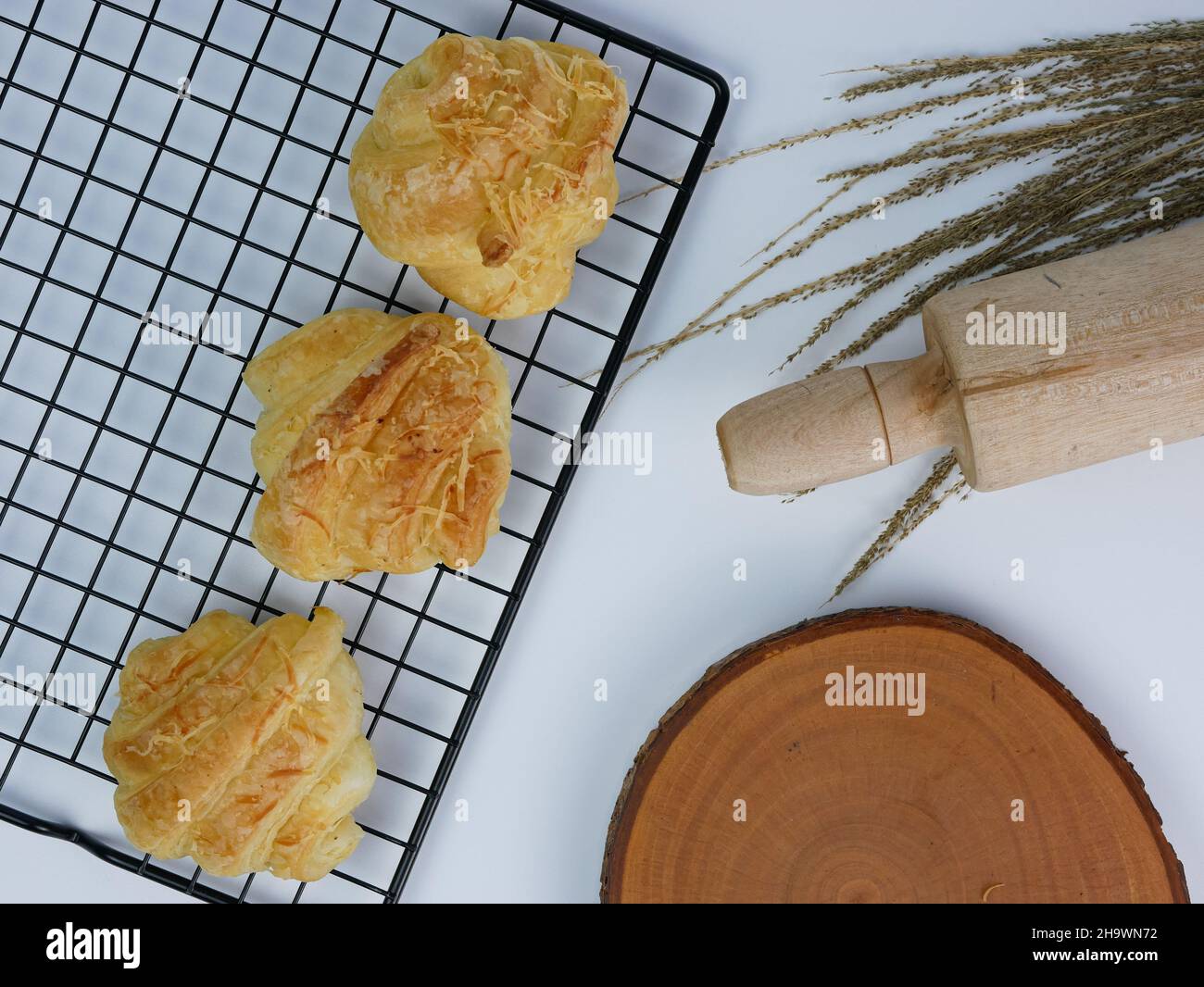 croissant sul grill, tagliere in legno e spilla su sfondo bianco Foto Stock