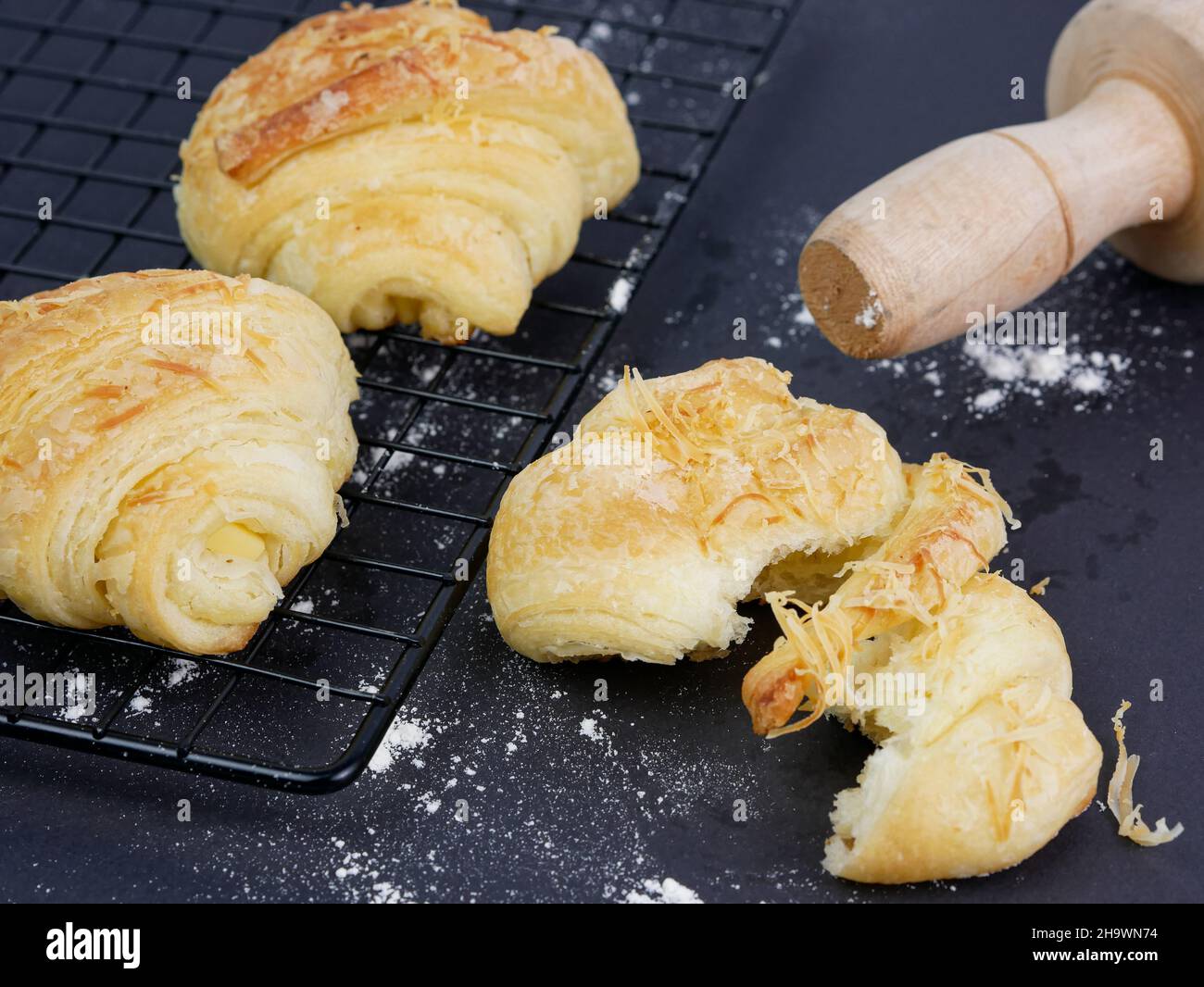 croissant alla griglia e croissant affettati, spille rotolanti, farina sparsa Foto Stock