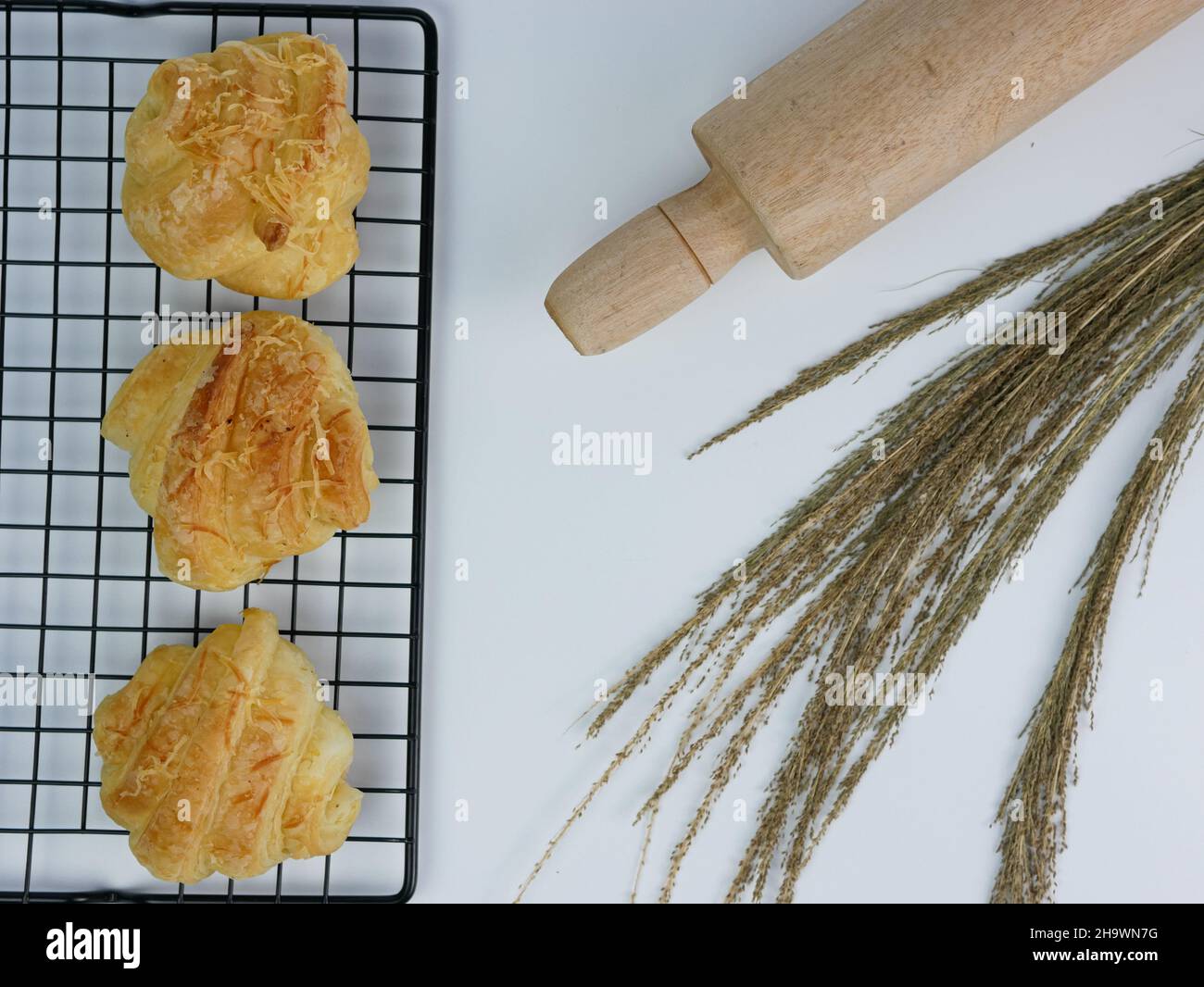 croissant sul grill e spilla rotante su sfondo bianco Foto Stock