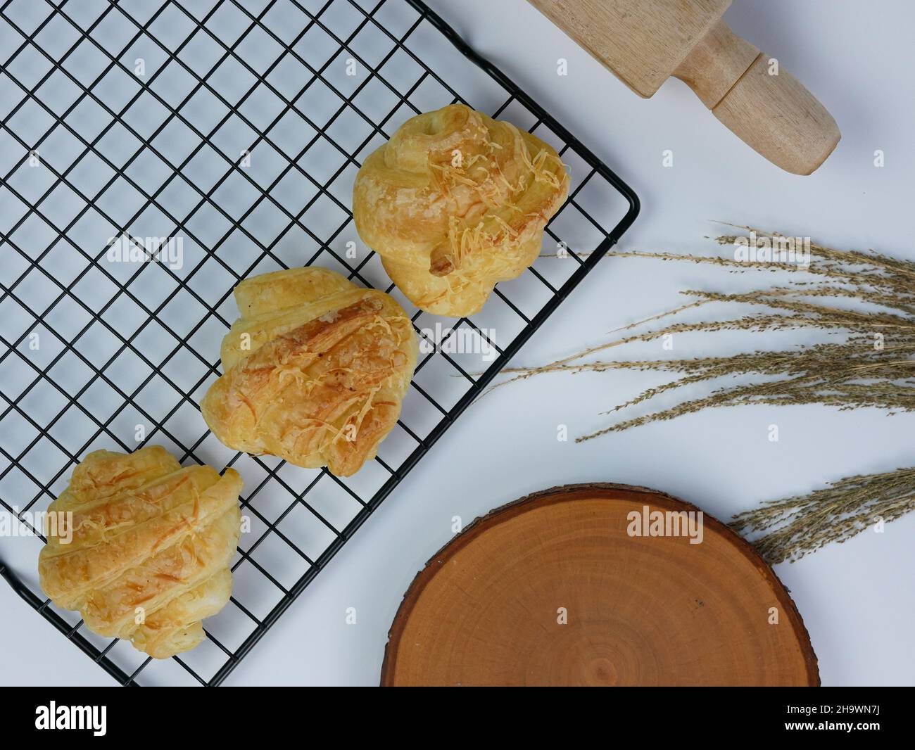 croissant sul grill, tagliere in legno e spilla su sfondo bianco Foto Stock