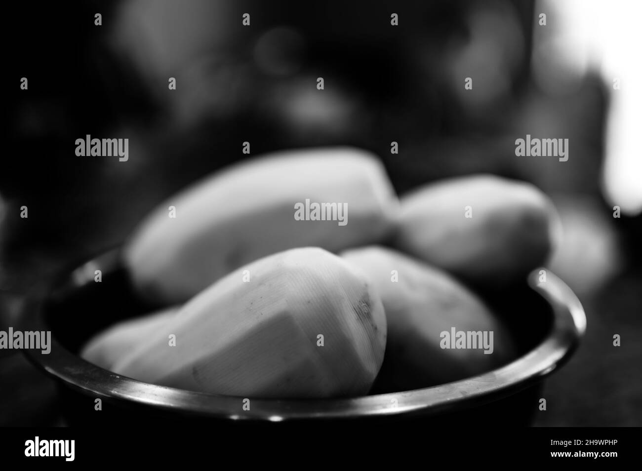 Focalizzazione selettiva sulle patate sbucciate in un recipiente metallico pronto per essere affettato e cotto Foto Stock