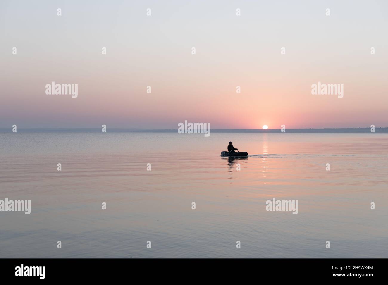 Mare all'alba con barca di gomma da pesca, calma, Mare di Azov, Russia. Foto Stock