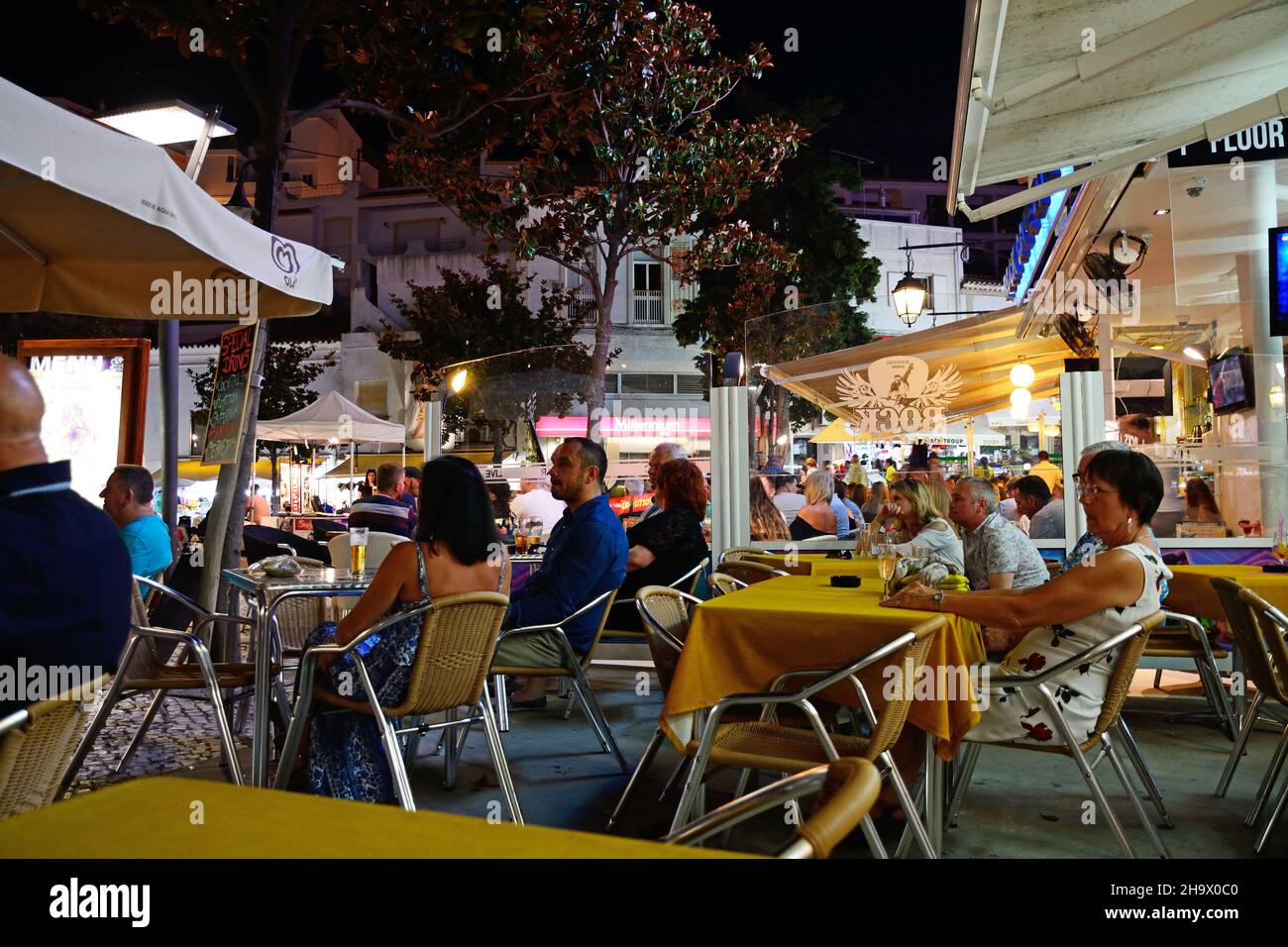 I turisti in un momento di relax a un bar nel Largo Duarte Pachero Square nella città vecchia di notte Albufeira, Portogallo, Europa. Foto Stock