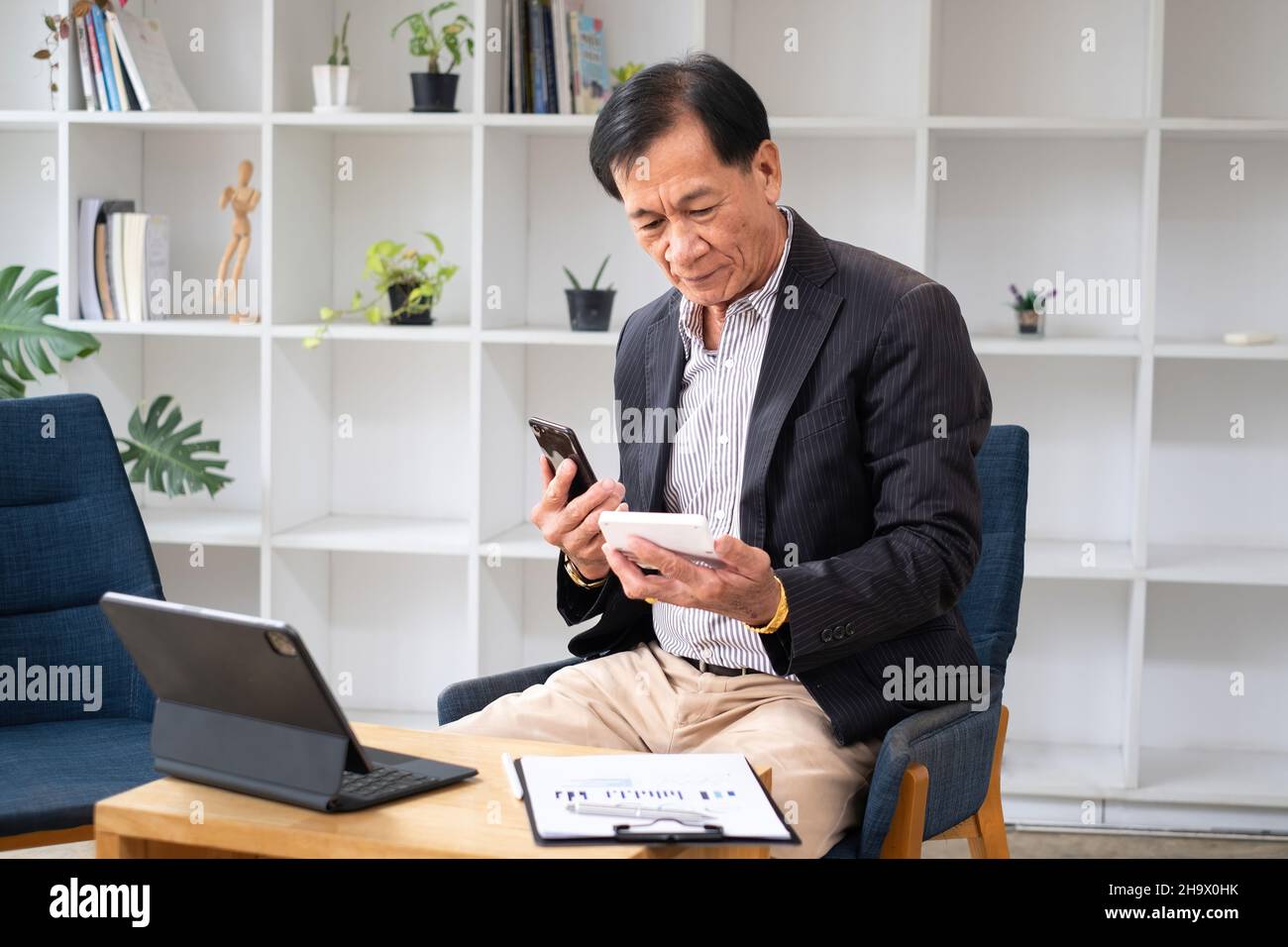 Calcolatrice e smartphone per l'azienda che utilizza l'applicazione di conto di risparmio bancario, il conto o il concetto di risparmio di denaro o assicurazione. Foto Stock