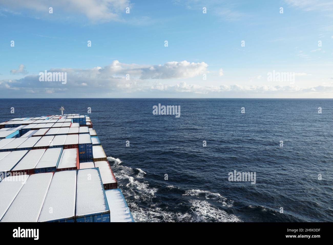 Vista dall'ala del ponte di navigazione della nave mercantile su contenitori coperti di neve Foto Stock