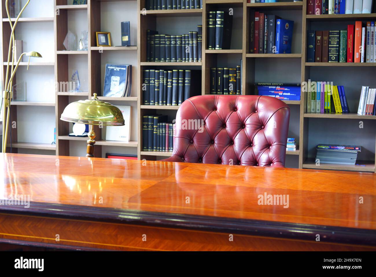 Scrivania Vintage Boss e sedia in pelle con scaffale sullo sfondo Foto Stock