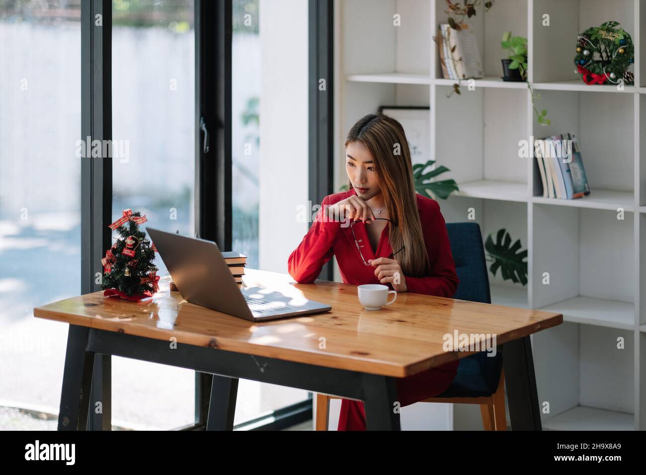 Ritratto di attraente donna d'affari asiatica che lavora con il laptop nel suo ufficio Foto Stock