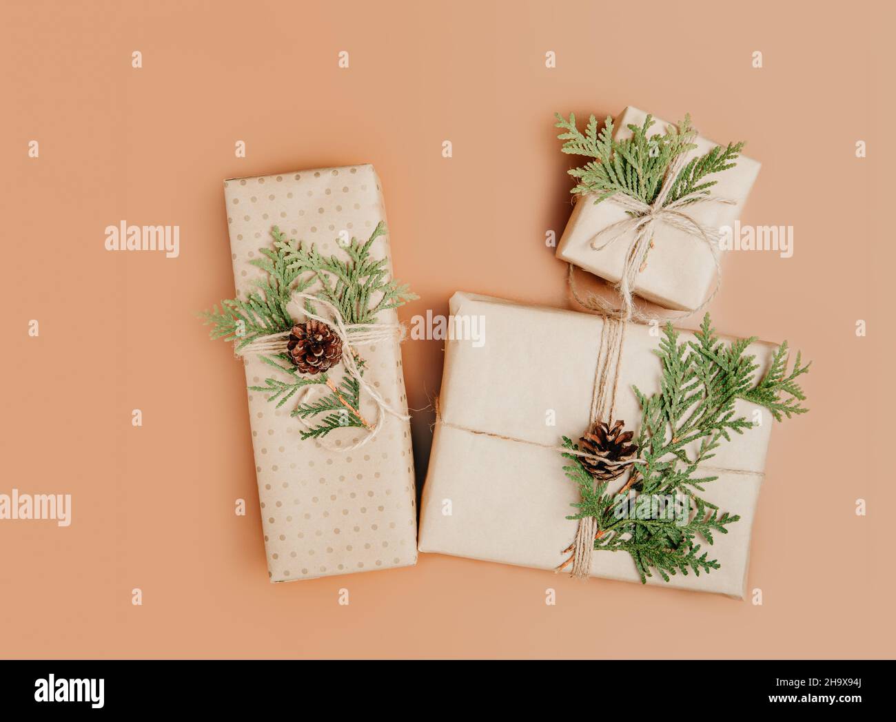 Scatole regalo avvolte in carta artigianale e decorate con ramo verde cipresso Foto Stock