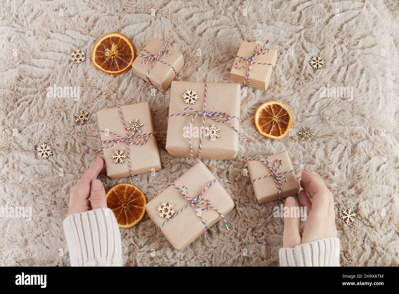 Zero spreco di Natale piatto. Mani che tengono semplice regalo di natale. Stile di vita sostenibile senza plastica Foto Stock