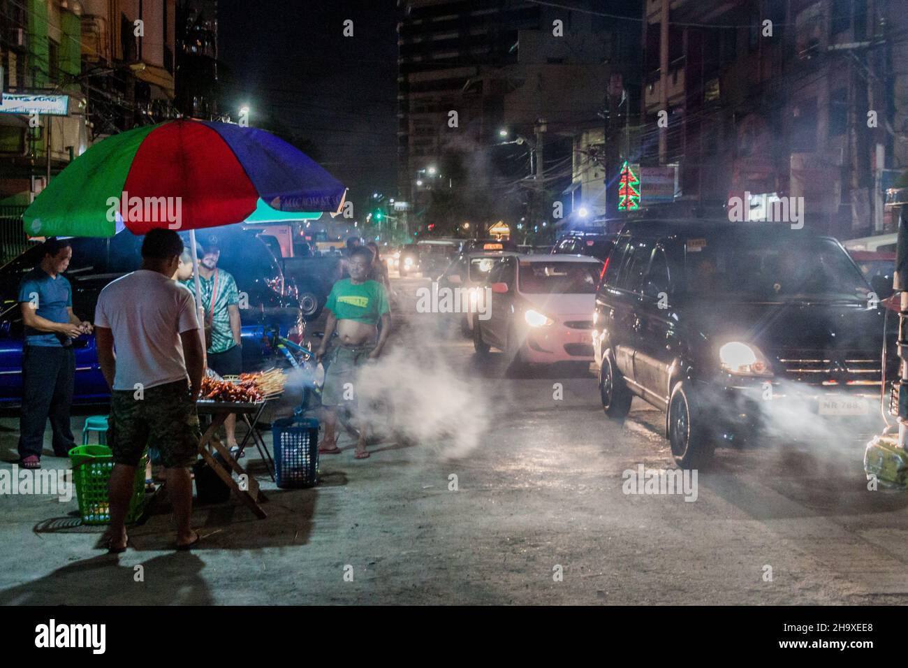 MANILA, FILIPPINE - 20 GENNAIO 2018: Vista di notte di una strada con uno stallo alimentare a Manila. Foto Stock