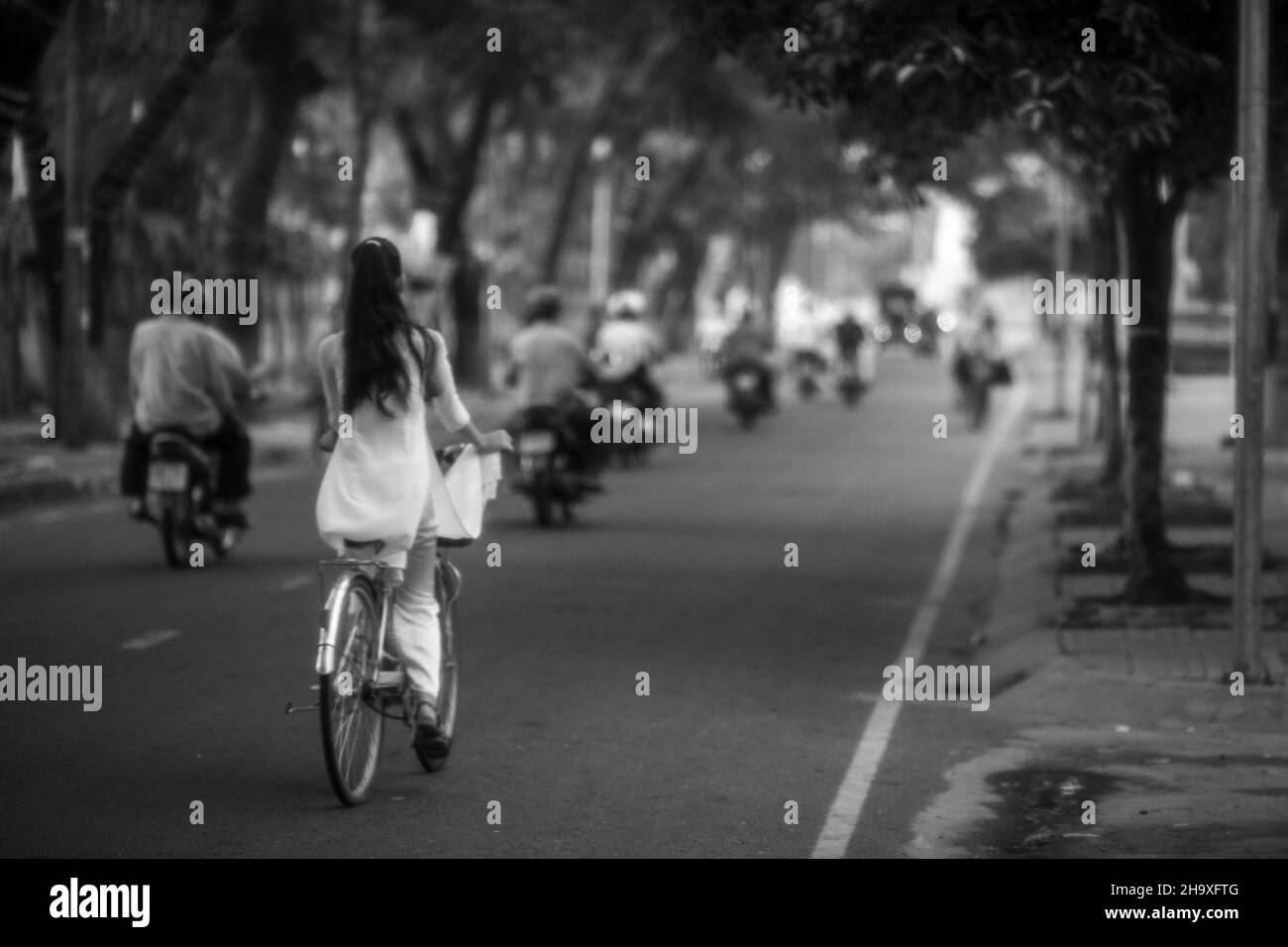 Le studentesse vanno a scuola in bicicletta sulla strada nella città di CA Mau, Vietnam Foto Stock