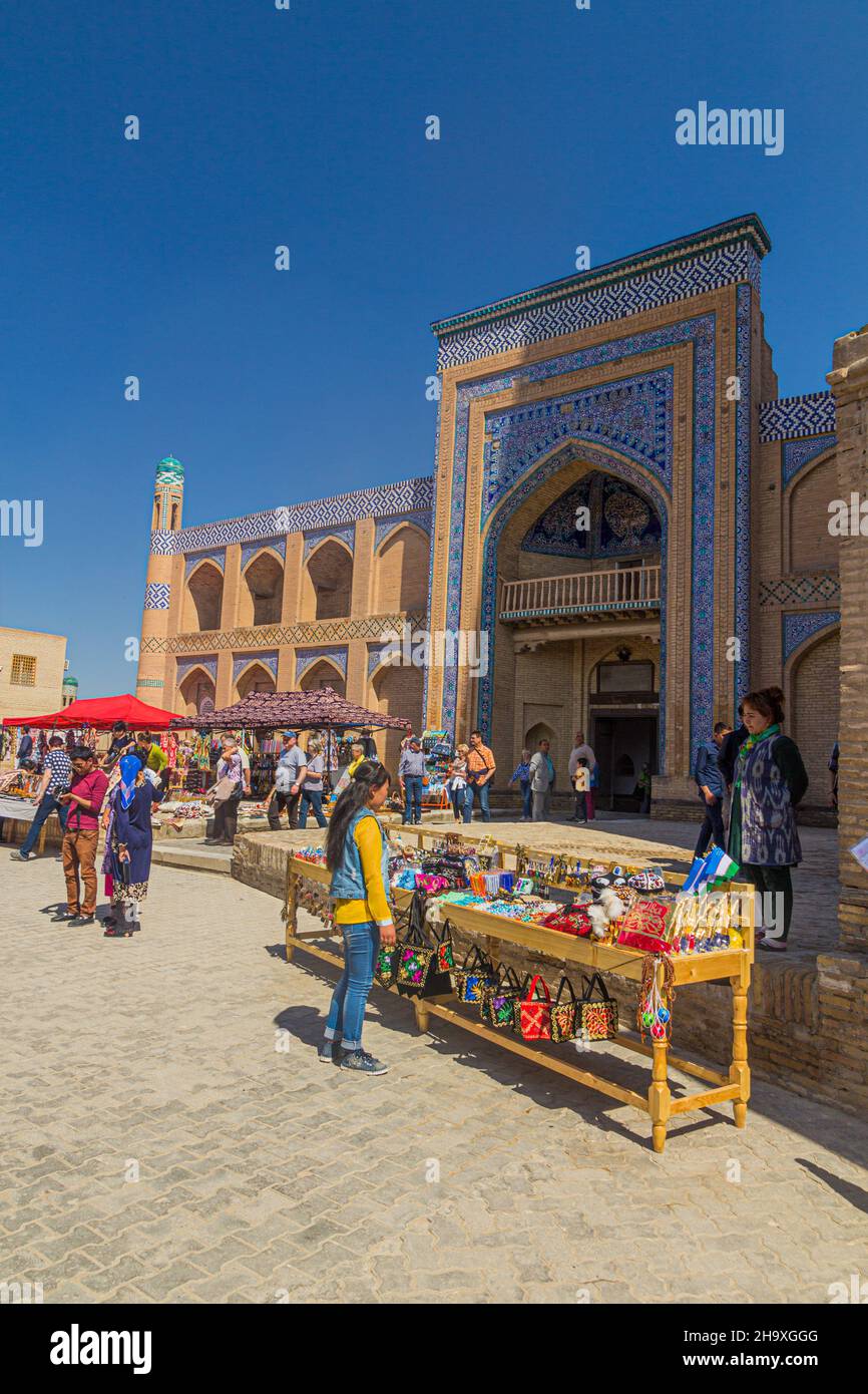 KHIVA, UZBEKISTAN - 26 APRILE 2018: Mercato di strada di fronte all'Islam Khoja Madrasa nella città vecchia di Khiva, Uzbekistan. Foto Stock