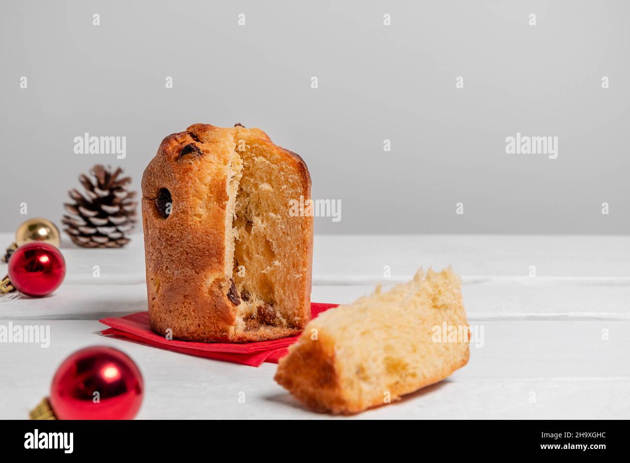 Dessert italiano mini panettone circondato da decorazioni natalizie su sfondo bianco con spazio copia. Il concetto di pasticceria di Natale o di Capodanno Foto Stock