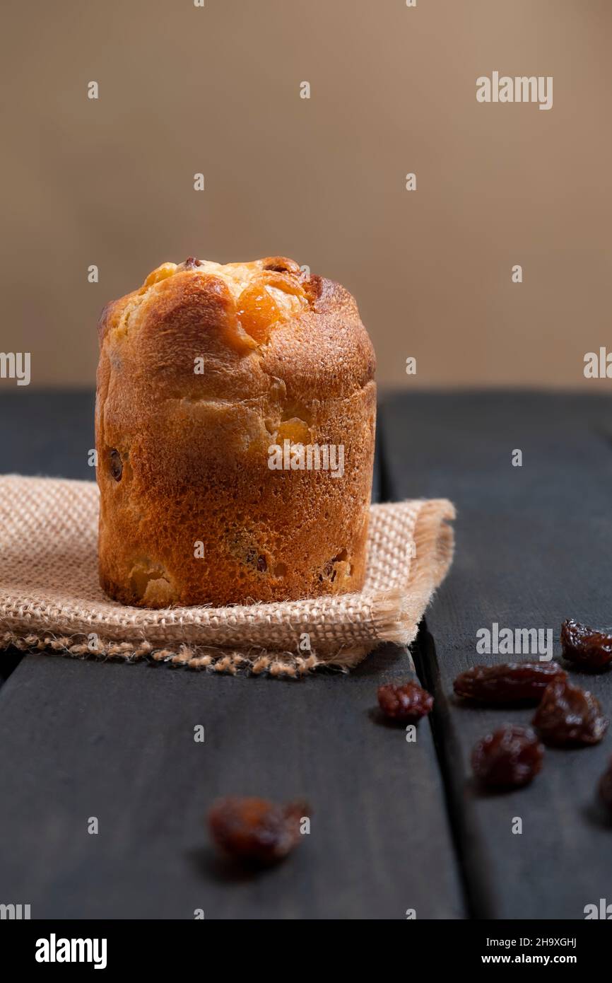 Dessert italiano mini panettone con uvetta su sfondo di legno scuro, orientamento verticale Foto Stock