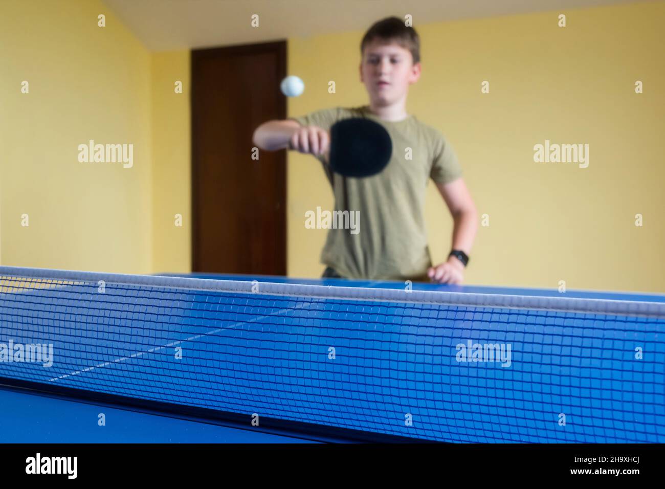 Ragazzo carino che gioca a ping pong al coperto. Ping pong. Foto Stock