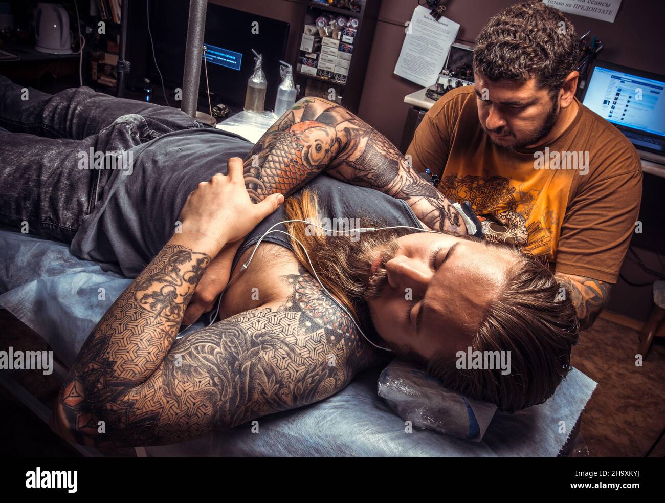 Tatuatore che fa tatuaggio in studio tatuaggio Foto Stock
