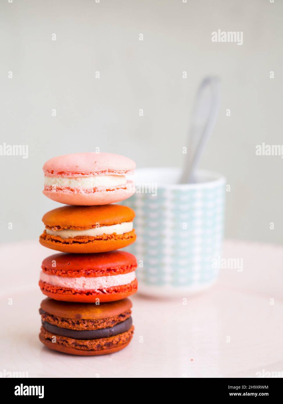 Un mucchio di macaron davanti a una tazza di caffè Foto Stock