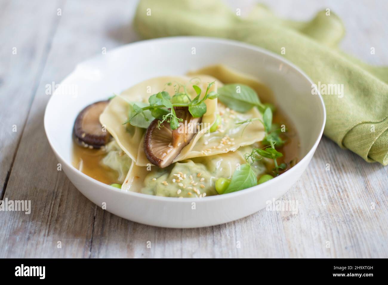 Gnocchi in brodo con edamame, funghi e crescione Foto Stock