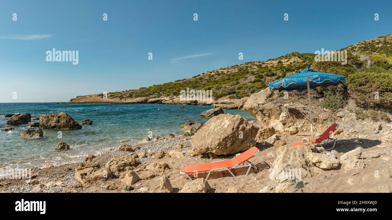 Sedie a sdraio e ombrellone presso la spiaggia di Alyki Foto Stock