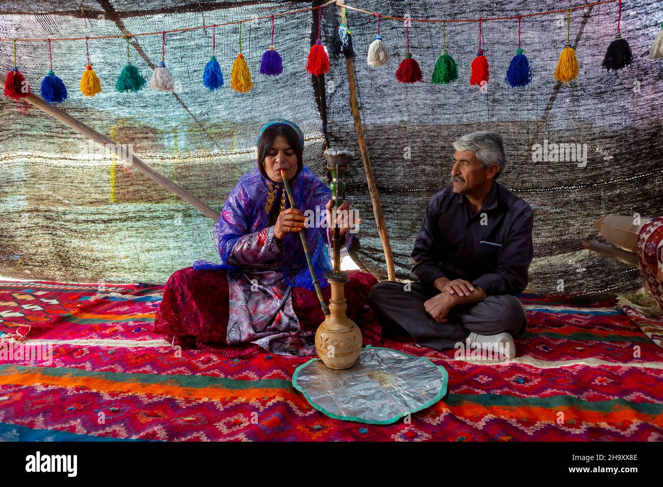 Shiraz, Iran - 11 maggio 2018: Qashqai nomade famiglia fumo hookah. Qasqhai sono persone nomadi che vivono in villaggi temporanei. Foto Stock