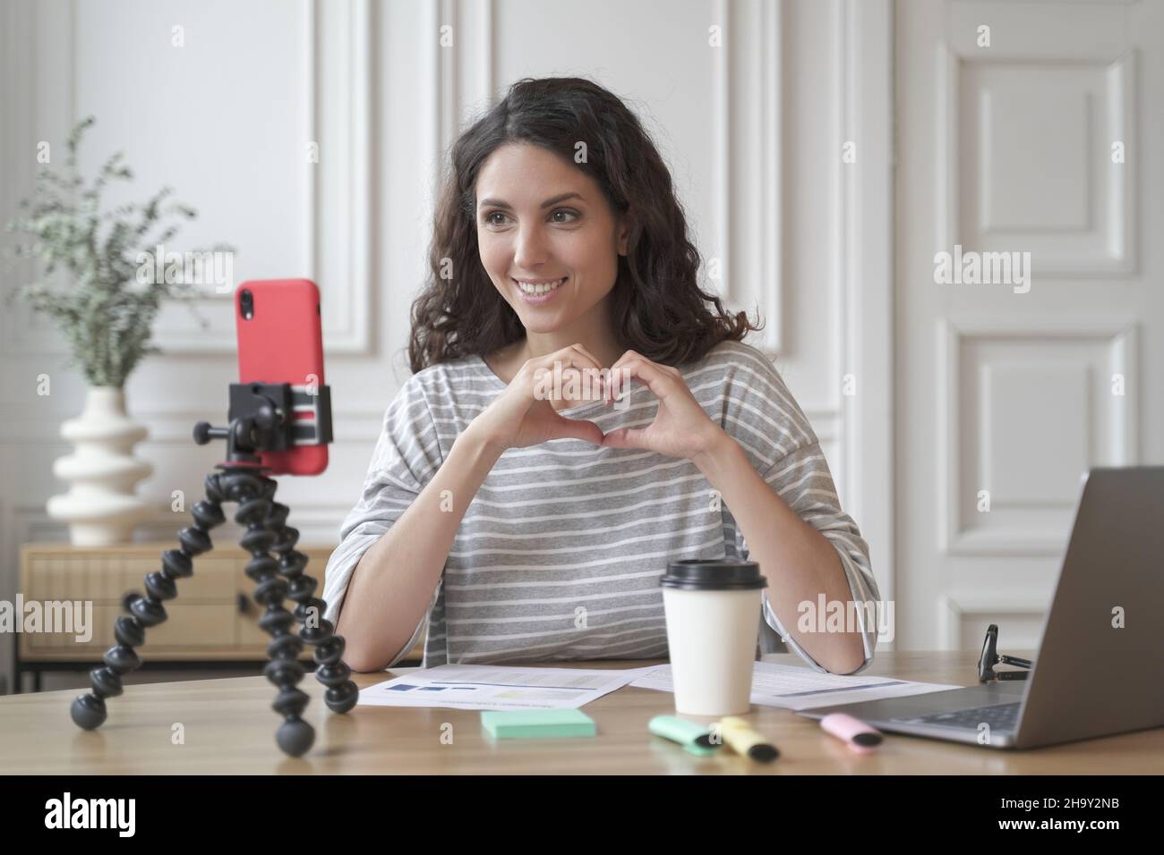 Giovane simpatica donna italiana blogger influencer seduto di fronte allo smartphone e filmare video Foto Stock