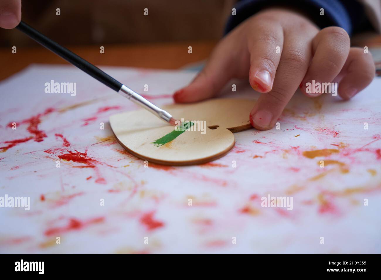 Le mani del bambino dipingono un cuore con un pennello. Sessione di arte e prescolare Foto Stock