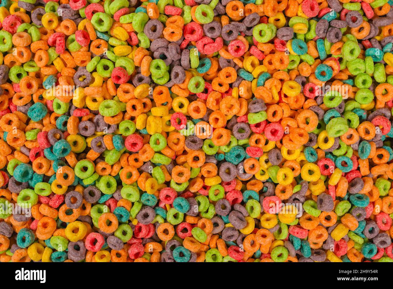 Dolci fiocchi multicolore, anelli di cereali come sfondo. Foto Stock