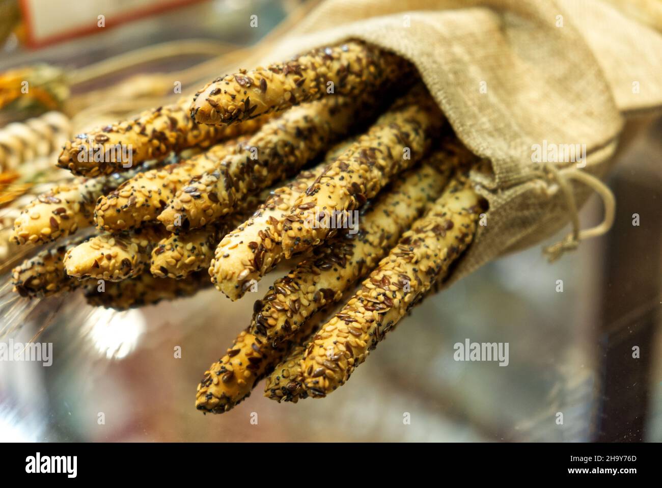 concetto di cibo vegano: composizione di grissini ricoperti di semi di sesamo e lino Foto Stock