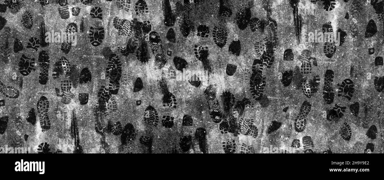 Sfondo invernale con stampe di scarpe sulla neve per strada Foto Stock