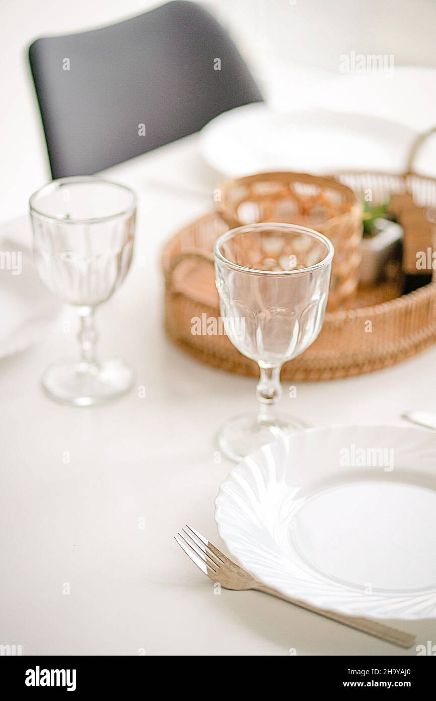 Due bicchieri da vino vuoti su un tavolo da pranzo con una tovaglia bianca, decorazione da tavolo, impostazione da tavolo. Primo piano. Foto di alta qualità Foto Stock