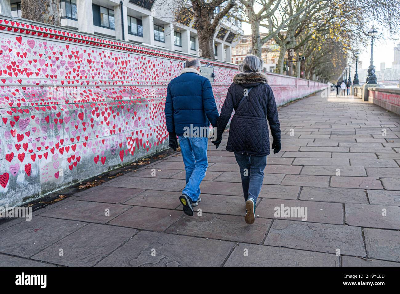 WESTMINSTER LONDRA, REGNO UNITO. 9 dicembre 2021. Un pedone passa accanto ai cuori dipinti al Muro commemorativo Nazionale di Covid lungo l'argine del Tamigi. il primo ministro Boris Johnson ha annunciato restrizioni più severe del piano B Covid durante un discorso televisivo da Downing Street il mercoledì sera, tra cui il lavoro da casa, indossare maschere e introdurre i passi Covid per combattere l'ascesa esponenziale della variante omicron alla luce dello scandalo del partito di Natale a Downing Street. Credit: amer Ghazzal/Alamy Live News Foto Stock