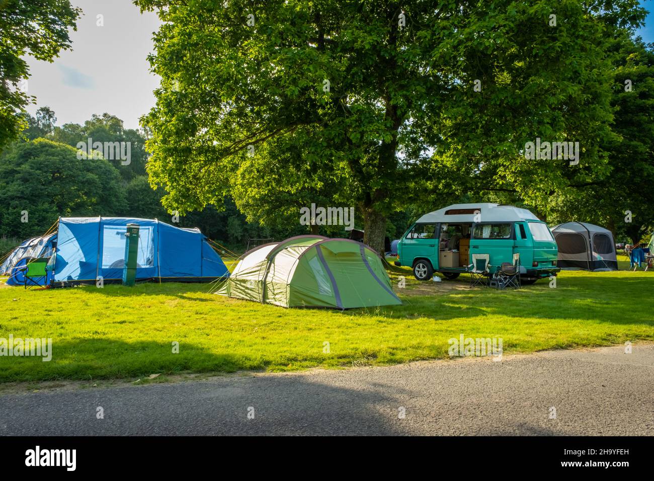 Furgoni e tende a camper al Colleland Campsite durante l'estate nel Parco Nazionale di Trossachs, Scozia Foto Stock