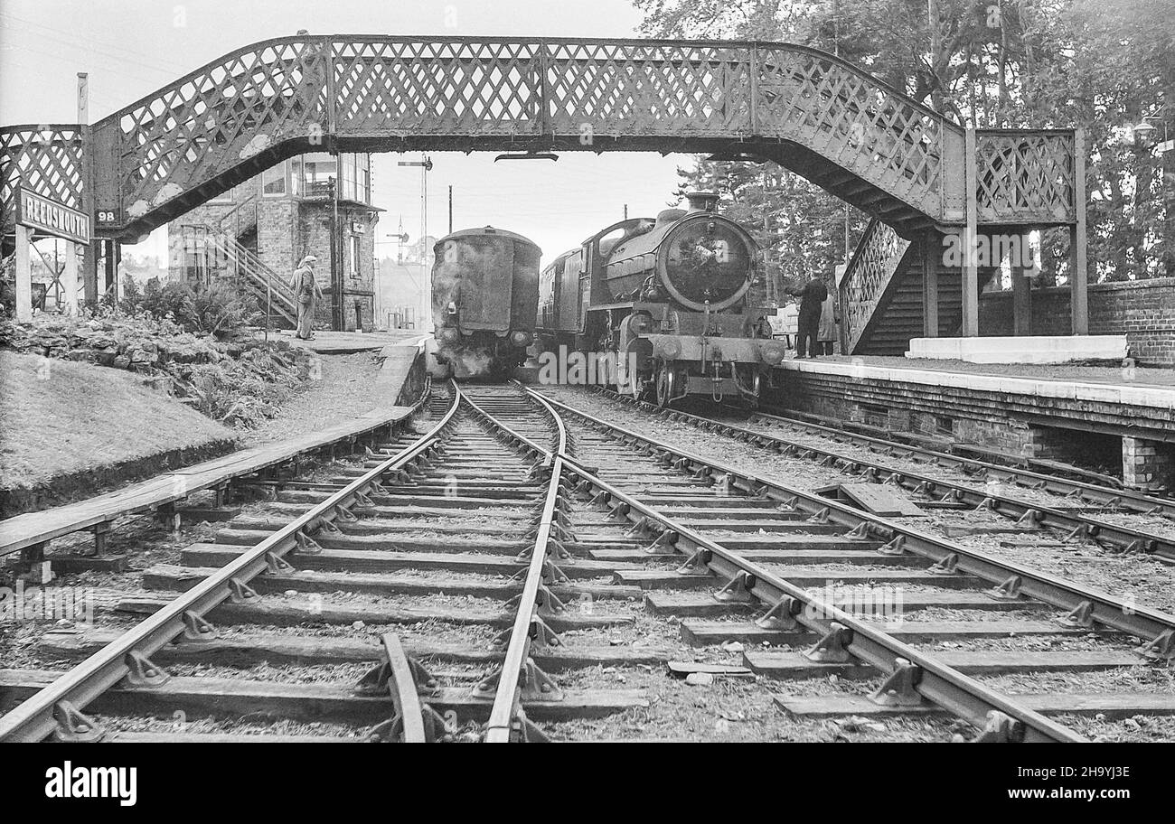 L'immagine da un negativo monocromatico scansionato è della stazione ferroviaria di Reedsmouth nel North Yorkshire come era nell'ottobre 1956 con il treno a vapore passeggeri 62022 in piedi inattivo in attesa di passeggeri Foto Stock