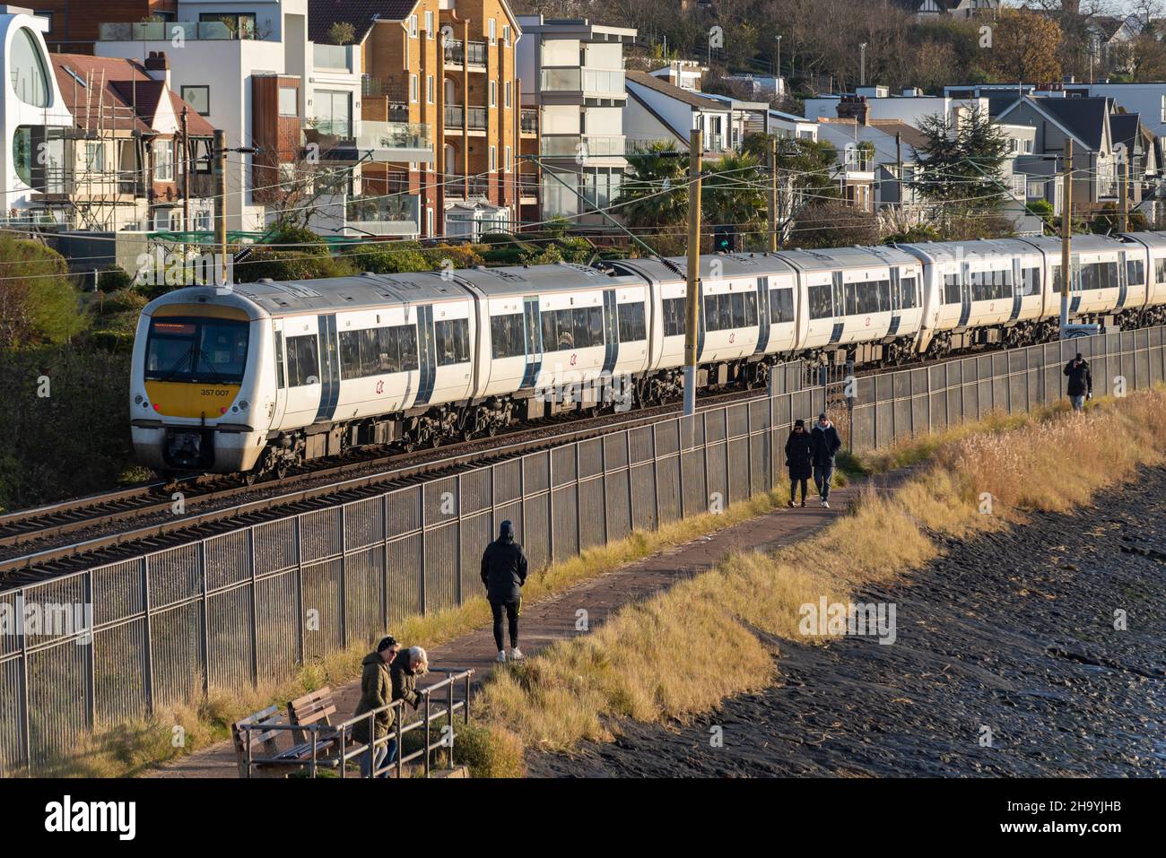 C2C treno che passa a piedi sulla pista di cinder a Chalkwell, Southend on Sea, Essex, Regno Unito. Elettrificato London Southend Railway gestito da Trenitalia Foto Stock