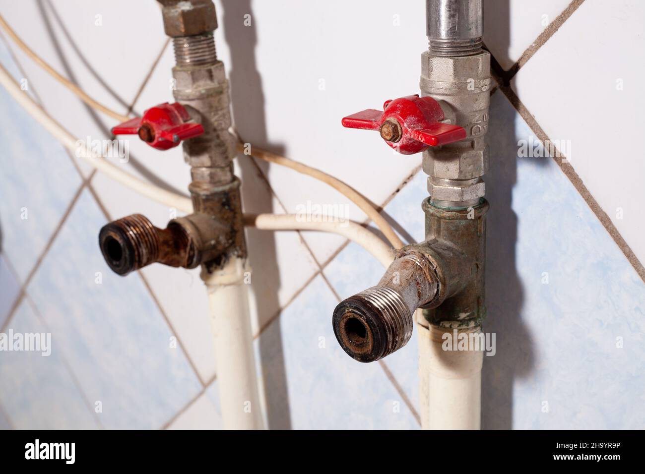 Vecchi tubi arrugginiti e raccordi idraulici su condutture d'acqua. Eliminazione delle perdite di acqua. Riparazione fai da te a casa. Foto Stock