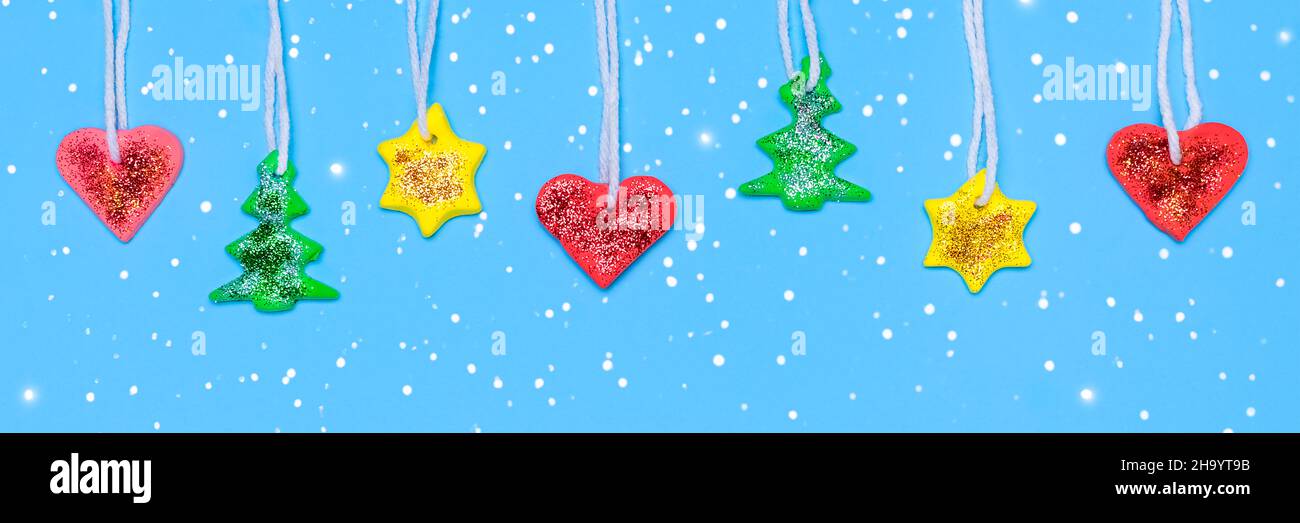 Fai da te Garland per l'albero di Natale. Albero FUT, stella e cuore in plastica rossa, gialla e verde. Banner di Natale o Capodanno lungo. Plastilina Foto Stock