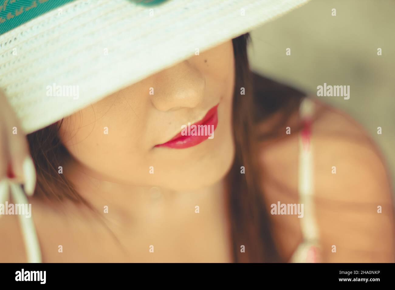 Close up ritratto di una bella ragazza che indossa una bianca cappello per il sole Foto Stock
