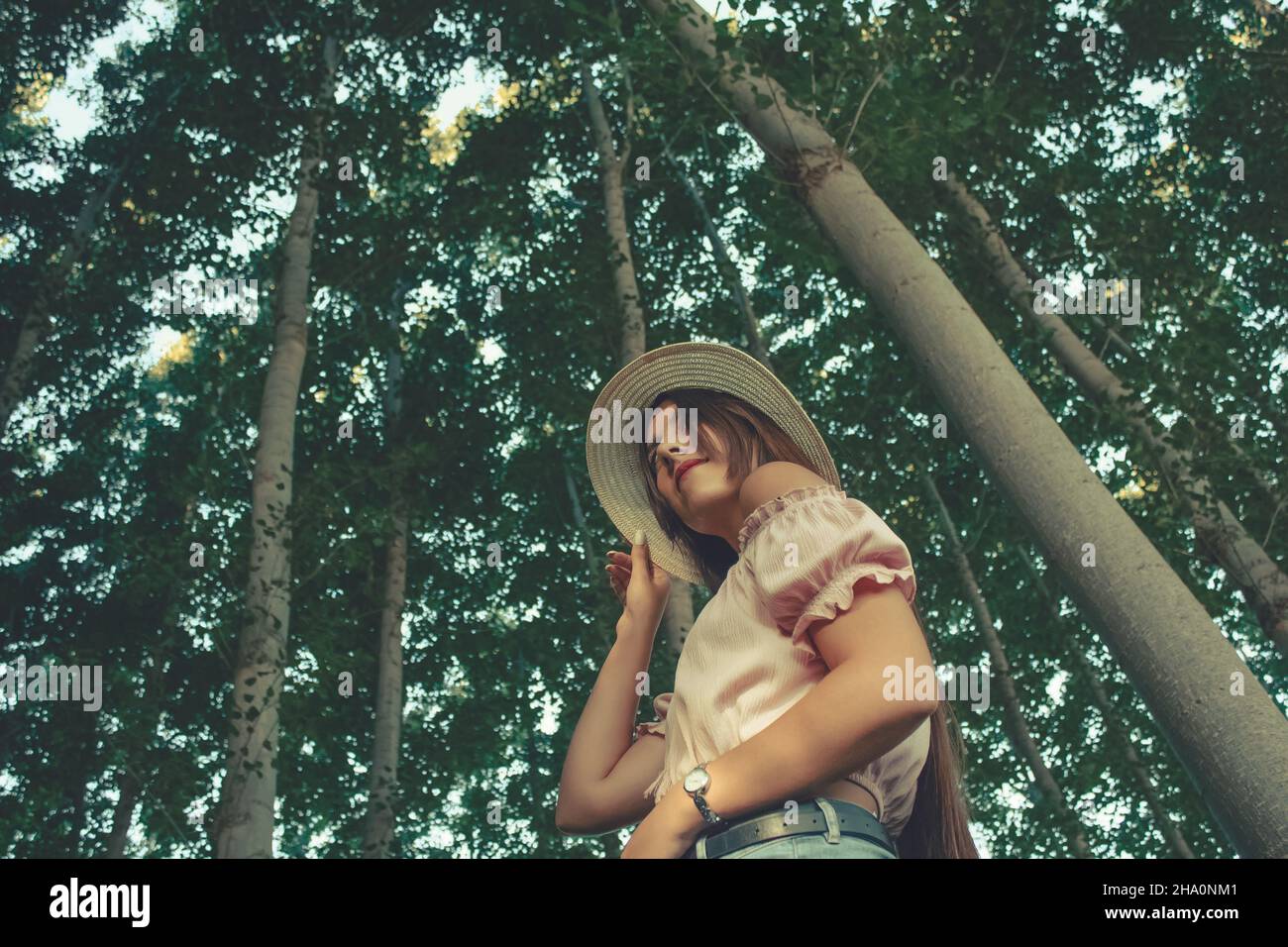 All'aperto in verticale verso il basso prospettica di una giovane bella bruna ragazza indossando un cappello per il sole Foto Stock