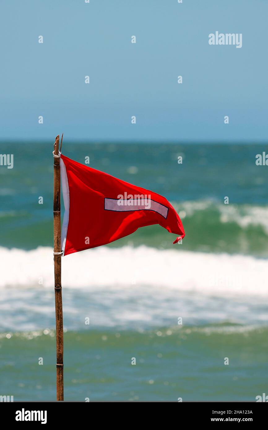 Bandiera rossa guardia di vita pericolo cartello di avvertimento sulla spiaggia. No nuoto è vietato simbolo, pericolose correnti di marea lacerata sull'acqua, entrare al vostro a rischio. Foto Stock