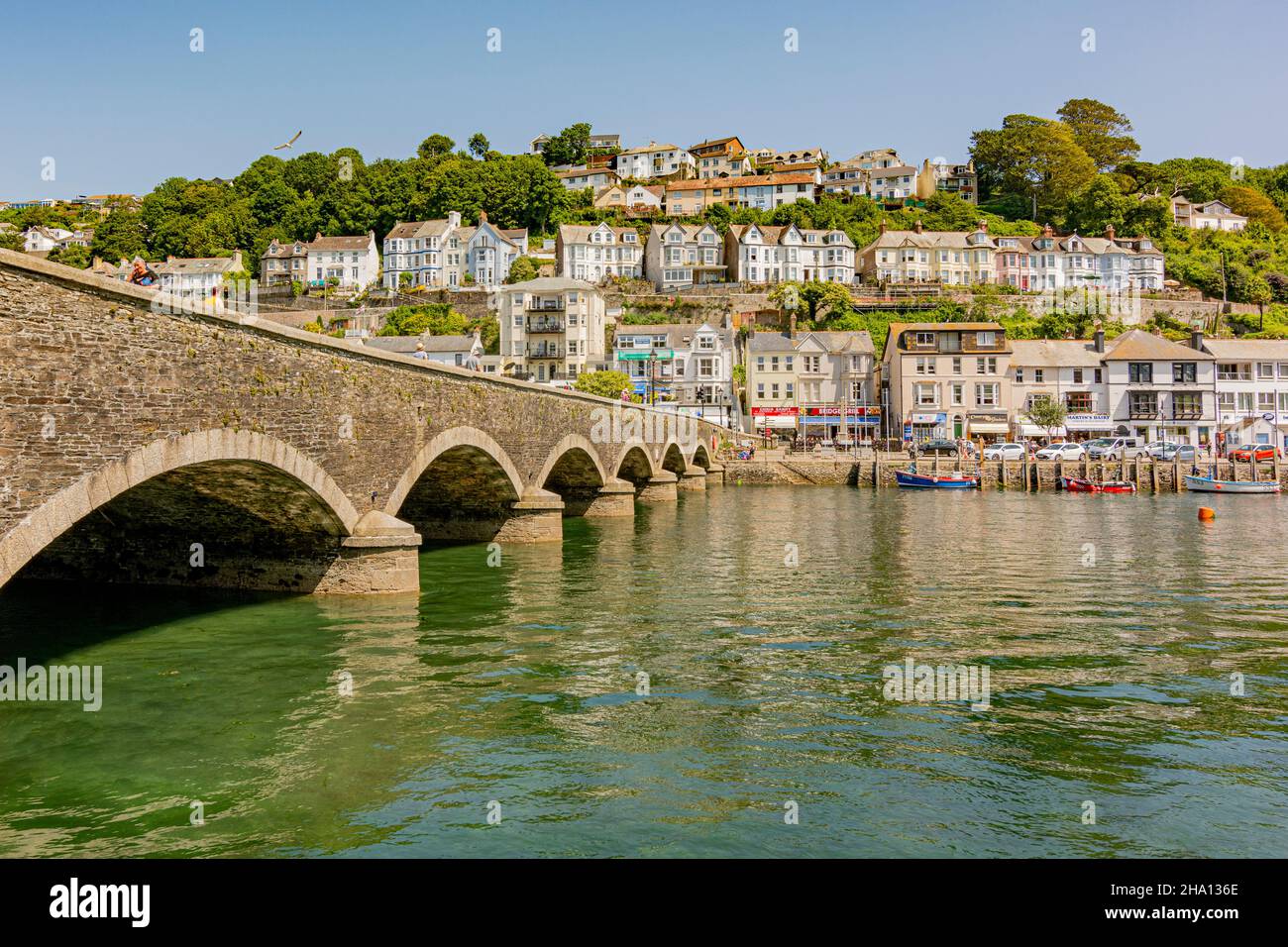 Il ponte classificato di grado II sul fiume East Looe con abitazioni in collina e negozi di East Looe - Looe, Cornwall, Regno Unito. Foto Stock