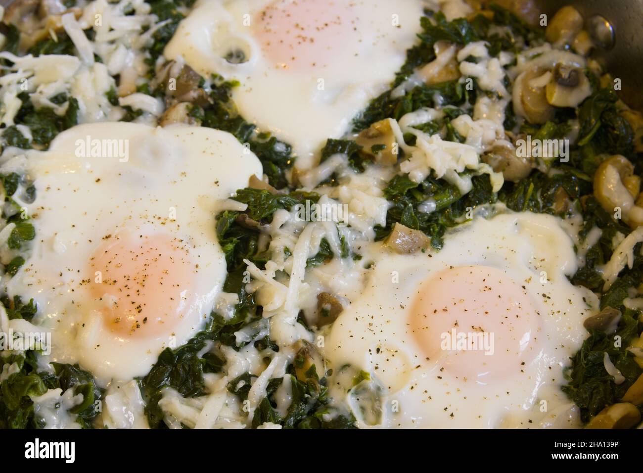 Immagine di una ricetta per uova fritte con spinaci e spezie ricche di ferro Foto Stock