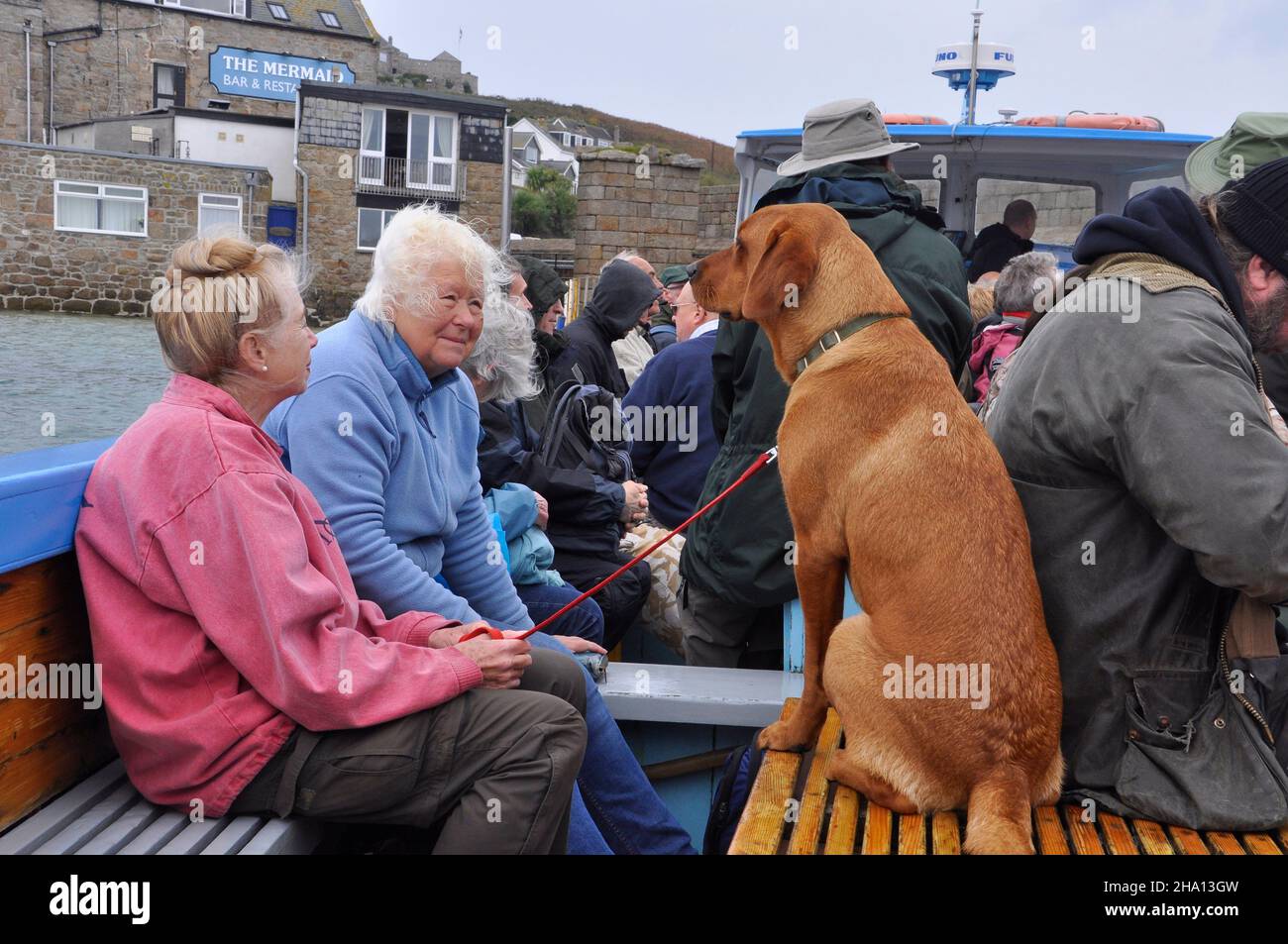 Tourist con il suo cane da compagnia in una delle barche inter-isola attende di lasciare il Quay Old in Hugh Town su St Marys nelle isole di Scillies.Cornwall.UK Foto Stock