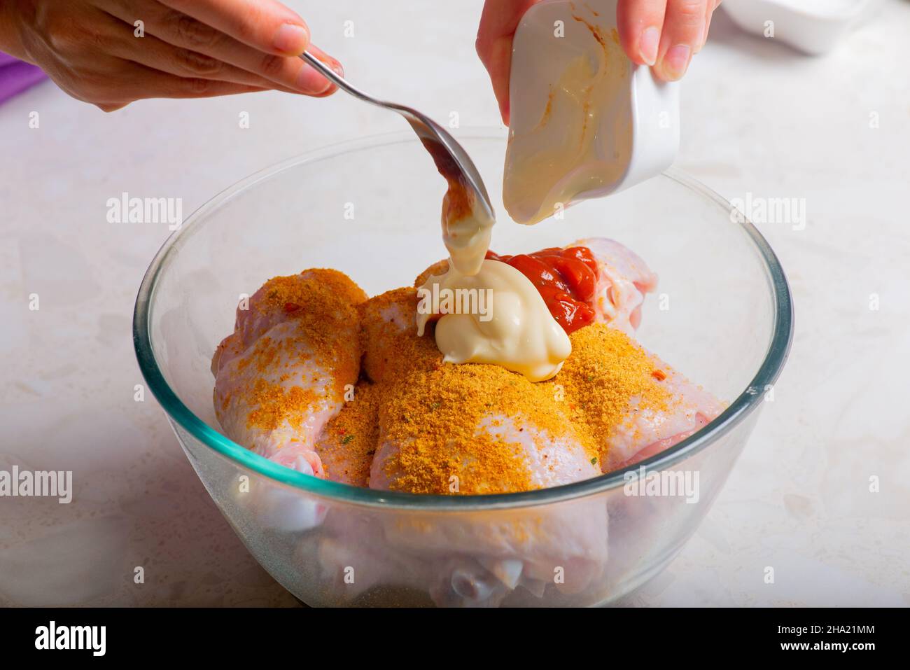 i polsini di pollo in una tazza sono cosparsi di maionese Foto Stock