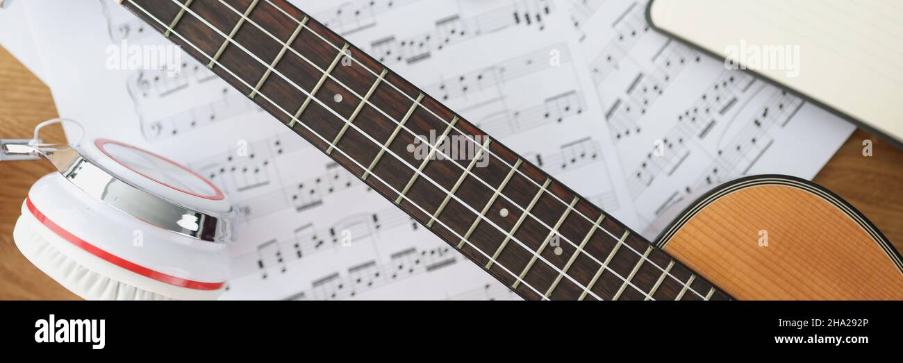 Cuffie per chitarra in legno e note musicali sul primo piano del tavolo Foto Stock