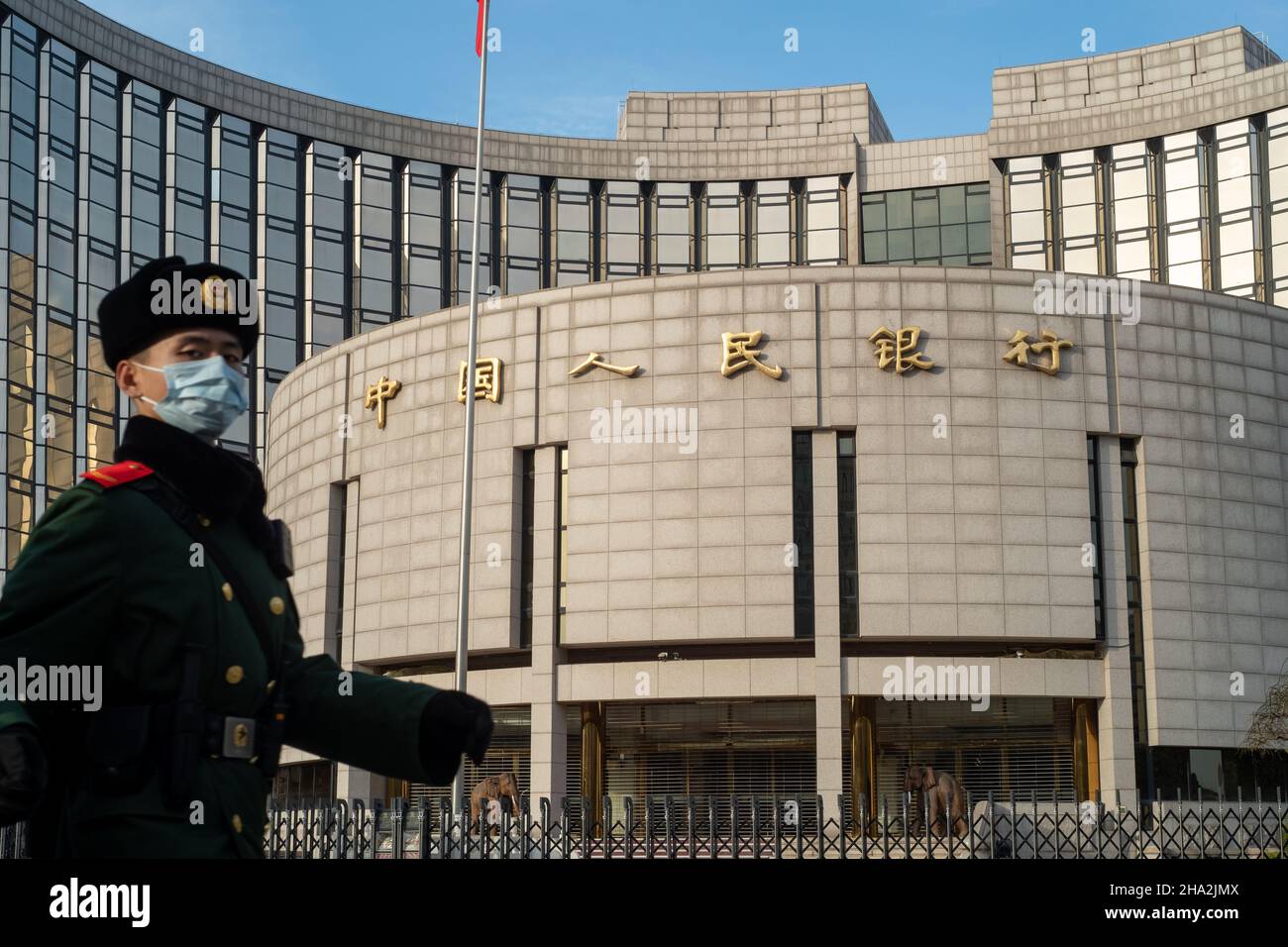 Un poliziotto paramilitare cinese passa davanti al quartier generale della Banca popolare Cinese (PBOC), la banca centrale cinese, a Pechino. 10-dic-2021 Foto Stock