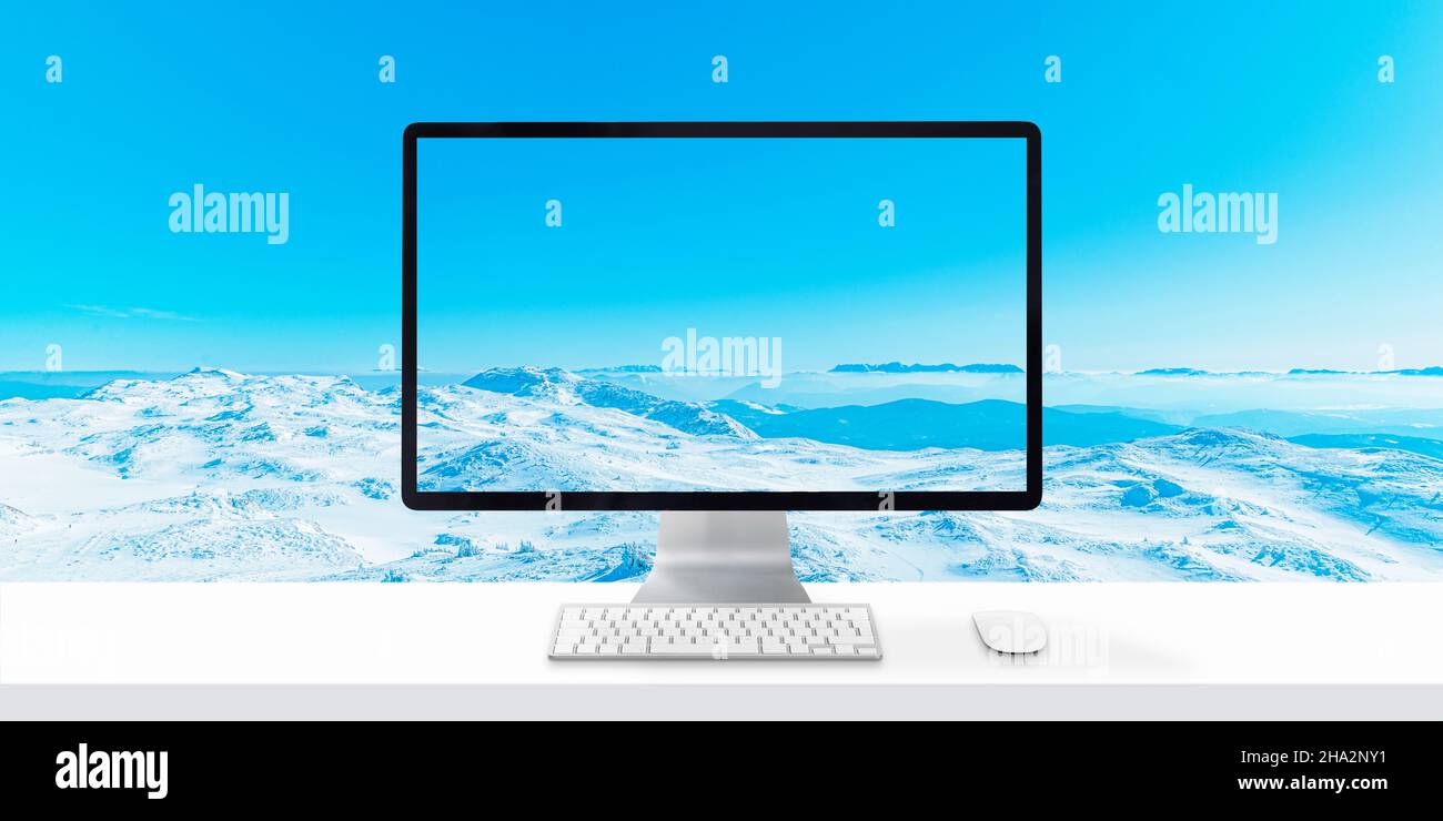 Computer su scrivania con orizzonte di montagna sullo sfondo. Concetto di viaggio invernale Foto Stock
